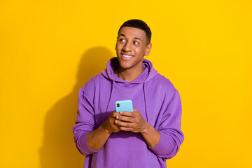 Portrait of handsome trendy cheerful guy using gadget creating post smm like isolated over bright yellow color background