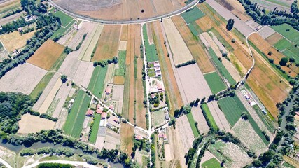 Aerial view of the agricultural fields, mountains and river in the countryside.