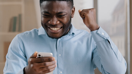 African young man surprised receive good message on cellphone win online bet rejoice passing mobile...