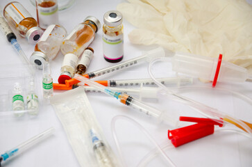 Medicines, syringes, ampoules medical supplies for droppers on the table. Medications randomly scattered across the table. Focus in the background. 
 View from above.