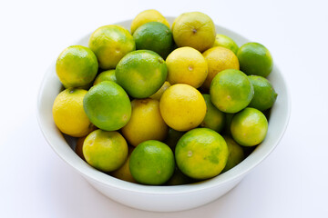 Frsh limes in bowl on white background.