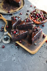 Dark chocolate cake with chocolate icing and seasonal cherries. Baking with alkalized cocoa with summer fruits and berries.