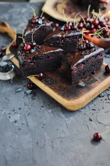 Dark chocolate cake with chocolate icing and seasonal cherries. Baking with alkalized cocoa with summer fruits and berries.