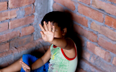 Boy showing hand signal to stop beating. useful to campaign against violence and pain. Stop child...