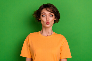 Fototapeta premium Photo of funky sweet young lady wear orange outfit sending you kiss isolated green color background