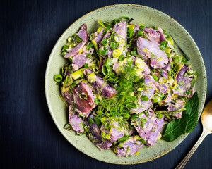 Vegan potato salad made with blue potatoes, fresh herbs and tahini
