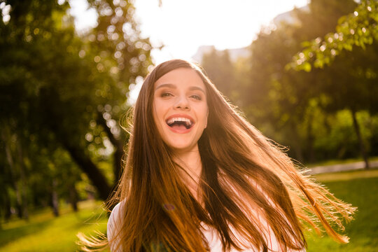 Photo of pretty cheerful young lady toothy beaming smile enjoy spend free time walk outside