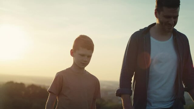 Little boy walking with dad at the meadow during the sunset. Shot with RED helium camera in 4K. 