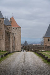 Fototapeta na wymiar Cobblestone path in the outer bailey of the medieval city of Carcassonne