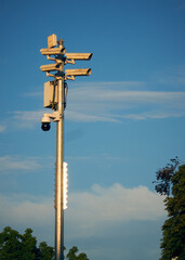 Several seurity cameras in the city with trees et blue sky