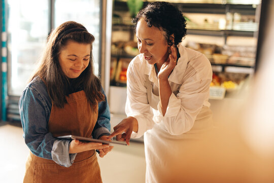 Supermarket workers using a digital tablet together