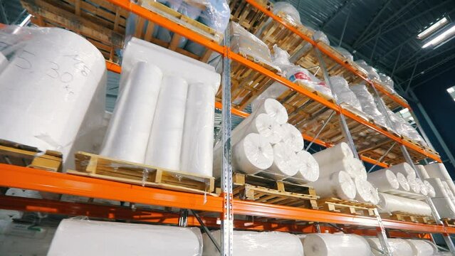 Warehouse with rolls of nonwovens. Large warehouse in a nonwoven fabric factory. Large roll of spunbond