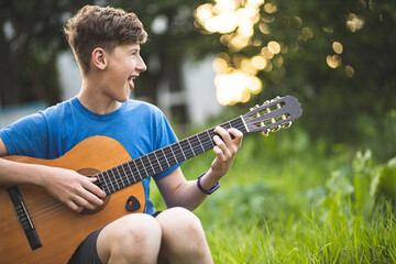 A teenager plays the guitar. Hobbies for teenagers. A teenager is engaged in music. Guitar lessons....