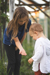 Fototapeta premium A sister is playing with her brother. A sister and her younger brother spend time together. Happy childhood. 
