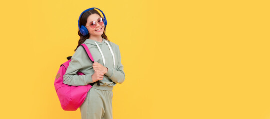happy child in earphones carry backpack. back to school. knowledge and education. Casual teen child horizontal poster. Banner header, copy space.