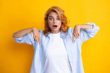 Woman point down at copy space, showing copyspace pointing. Promo, girl showing advertisement content gesture, pointing with hand recommend product. Isolated background.