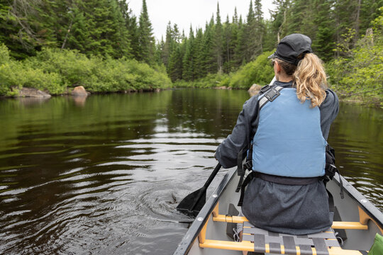 Jeune femme en canot sur une rivi&egrave;re calme