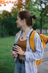 girl with coffee and backpack on city street