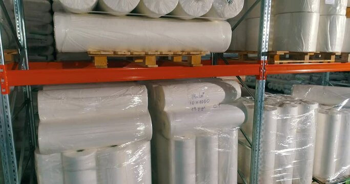 Warehouse at the nonwovens factory. Flight to the warehouse of non-woven fabrics. Large modern warehouse with synthetic winterizer rolls