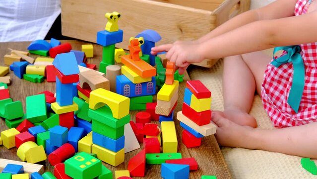 smart little child, girl 3 years old playing with educational toy, wooden geometric figures, blocks, kindergarten games, concept of childhood, earlier child development, creativity, early training