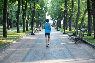 back view of athletic man runner running in sportswear outdoor