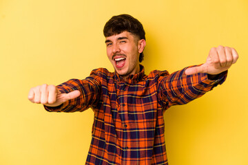Young caucasian man isolated on yellow background raising both thumbs up, smiling and confident.