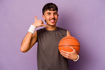 Obraz premium Young hispanic basketball player man isolated on purple background showing a mobile phone call gesture with fingers.