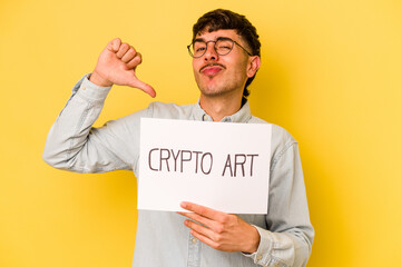 Young hispanic man holding crypto art placard isolated on yellow background feels proud and self...
