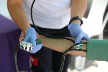 Close Up Of Doctor Measuring Patients Blood Pressure With Stethoscope