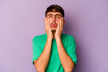 Young caucasian man isolated on purple background whining and crying disconsolately.