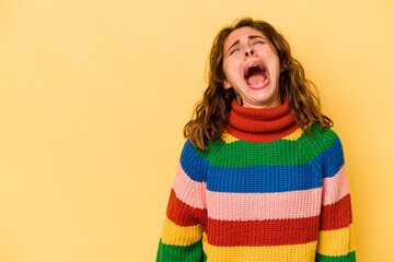 Young caucasian woman isolated on yellow background shouting very angry, rage concept, frustrated.