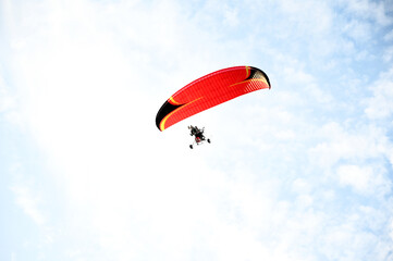 paramotor vehicle flying over a clear blue sky, view from below