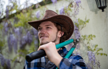 Young farmer carrying pruning scissors on shoulder
