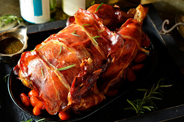 Roasted whole chicken with rosemary on a black tray