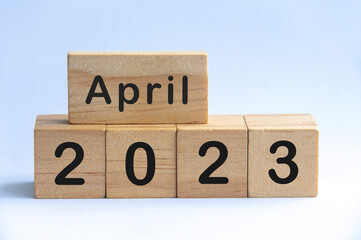 April 2023 text on wooden blocks with white color background. Copy space