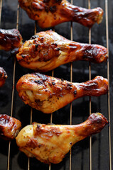 Roasted chicken drumsticks on a metal grill rack