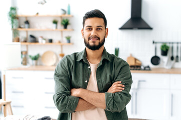 Handsome confident attractive modern indian or arabian guy, in casual stylish clothes, standing at...