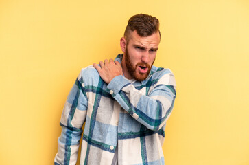 Fototapeta premium Young caucasian man isolated on yellow background having a shoulder pain.