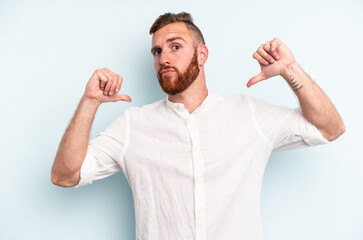 Fototapeta premium Young caucasian man isolated on blue background feels proud and self confident, example to follow.