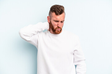 Young caucasian man isolated on blue background having a neck pain due to stress, massaging and touching it with hand.