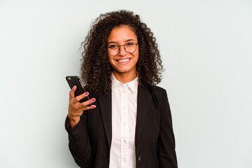 Young business Brazilian woman holding mobile phone isolated on white background happy, smiling and...