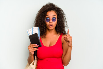 Naklejka premium Young brazilian woman wearing a swimsuit isolated on blue background pointing upside with opened mouth.
