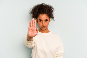 Young Brazilian woman isolated on blue background standing with outstretched hand showing stop...