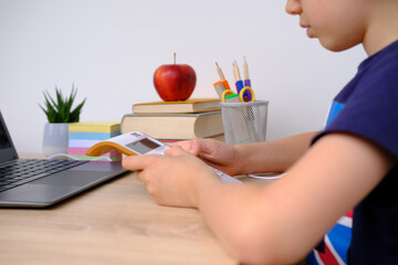 smart child, boy 7-8 years, primary school student calculates mathematical examples on electronic calculator, Back to school concept, doing homework, young businessman, child prodigy in class