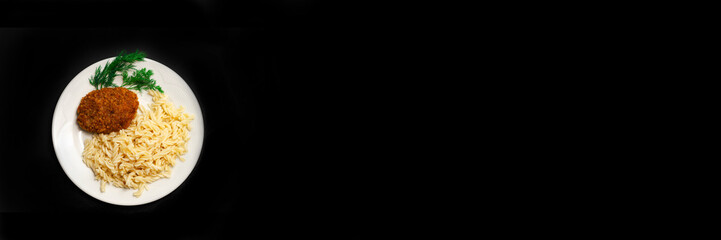 Meat cutlets with pasta and herbs on a black isolated background.