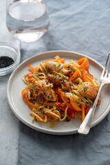 Stir fry noodles with chicken meat and vegetable, grey background. Asian style food, homemade food