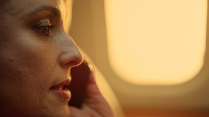 Beautiful woman chatting phone at porthole closeup. Smiling passenger on trip