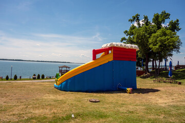 Fototapeta na wymiar Inflatable slide for children at the lake of the recreation center