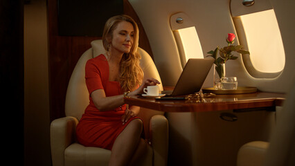 Entrepreneur working laptop computer on corporate first class journey alone.