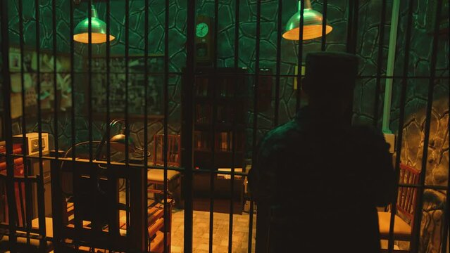 Dark jail cell at night . Hanging Swaying swinging lamps on dark room . Silhouette of policeman opening Interrogation room before interrogating . Prison life concept . Shot on camera ARRI slow motion